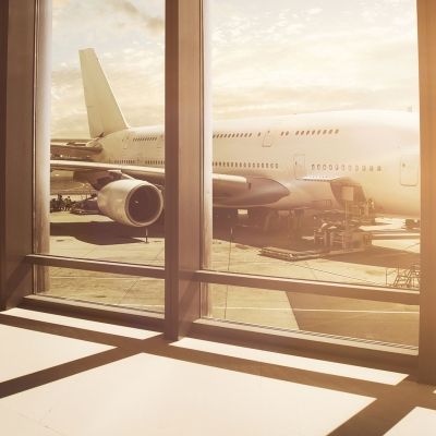 Inside of an airport looking out at a grounded airplane