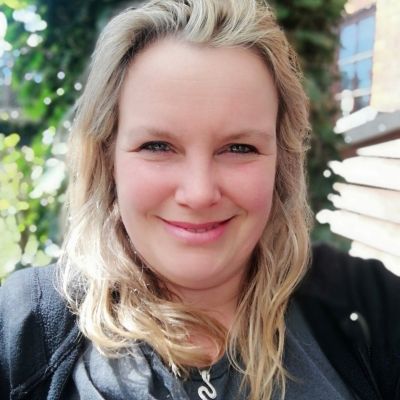 Head and shoulders photo of a smiling Alison Pearce looking stood face on and looking directly into the camera stood outside