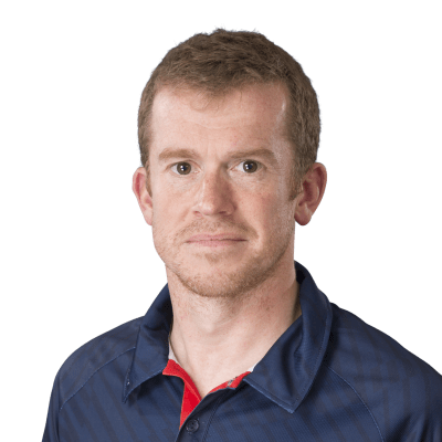 Head and shoulders shot of a smiling Mark Homer wearing a navy blue polo top and looking directly into the camera