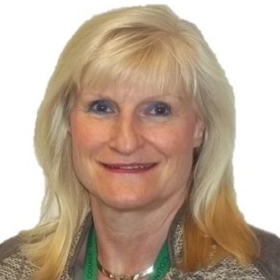 Head and shoulders picture of a smiling Karen Satterford stoofd face on and looking directly into the camera