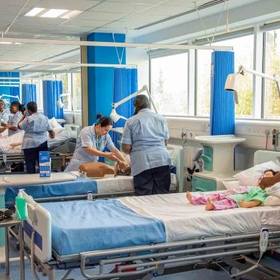 Nursing students in a hospital simulate suite attending to dummies