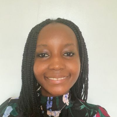 Head and shoulders photo of a smiling Nancy Chuchu stood face on looking directly into the camera