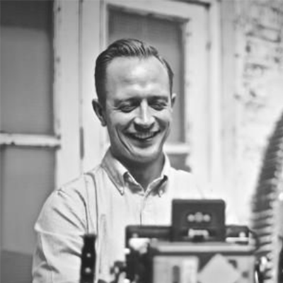 BNU student James Kayler wearing a shirt and smiling with his eyes closed