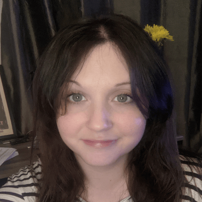A headshot of a smiling Georgia Capel wearing a striped top looking directly into the camera