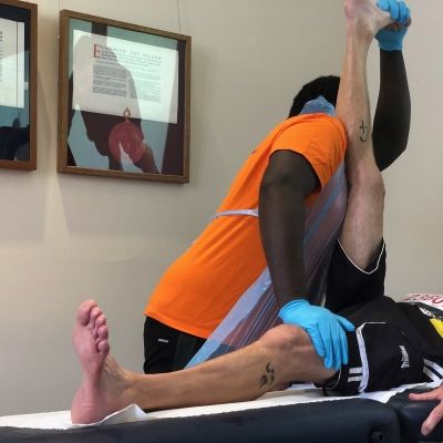 Students in MNDA uniform and PPE carrying out sports therapies on athletes