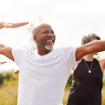 smiling people in a meadow holding yoga poses