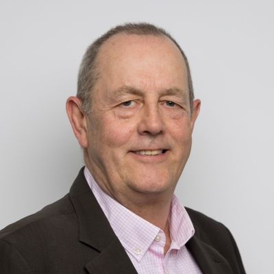 Photo of Matthew, a white man wearing a pink shirt and black suit jacket