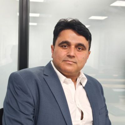 Photo of Altaf, who has light brown skin and short black hair, and is wearing a navy coloured suit jacket