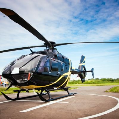 A black helicopter on a landing pad
