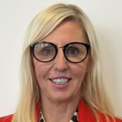 Headshot of Lecturer Tina Benbow wearing glasses and smiling.