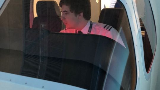 a student in the flight simulator with cameraman on the outside 