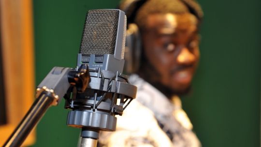 Bucks music student standing next to a vocal recording microphone