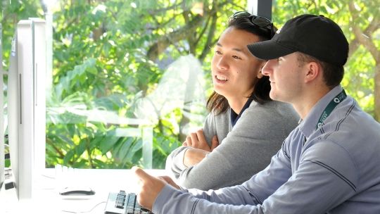 Two students in the BNU library looking at a computer monitor