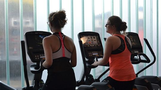 Two students on running machines in the gym