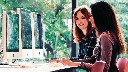 Two Bucks students using Macbooks in the Library