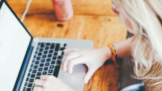 Female student typing on laptop studying