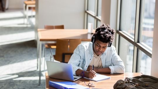 Source student in library studying
