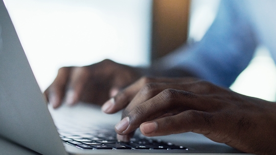 Male hands typing on laptop