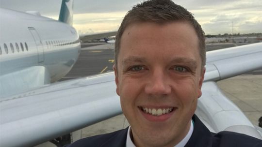 Darren Palmer stood in front of an airplane wing