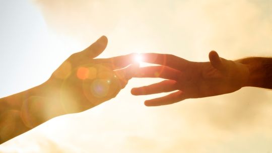 Two hands together infront of sun set