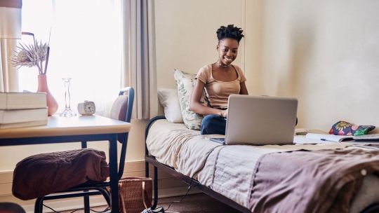 black female student in halls of residence bedroom