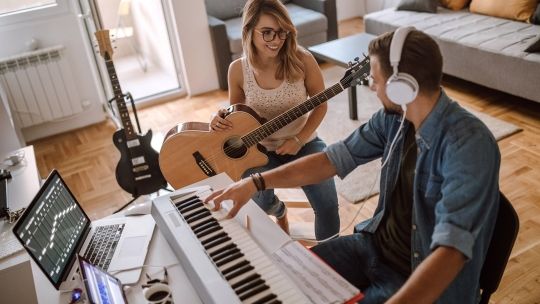 Source Musician Having Band Rehearsal In Comfortable Living Room
