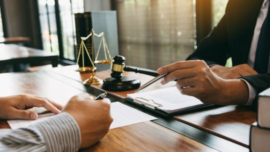 Hands of two male lawyers signing contracts