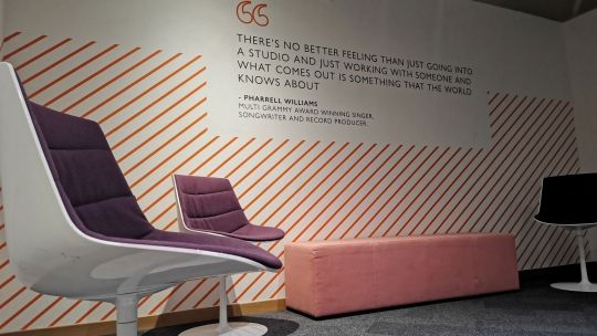 chairs on a stage with quote on wall in the background
