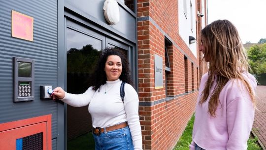 Two female students at the entrance of Hughenden accommodation