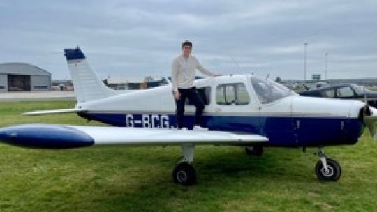 Ed Booth student stood on a plane at airpark