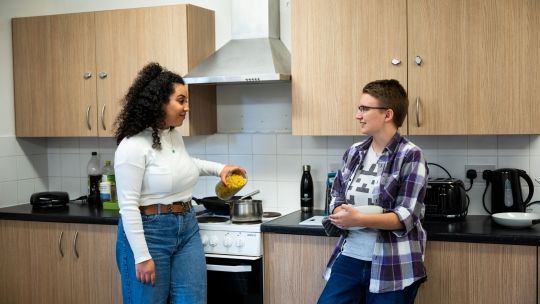 Two students cooking at Hughenden accommodation's shared kitchen