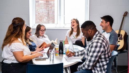 Group of students sitting at the table at Brook Street accommodation in High Wycombe campus