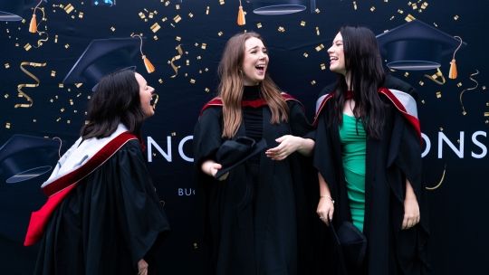 Three females graduands laughing 