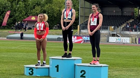 Marli stands on the podium with the winners of the gold and silver medals