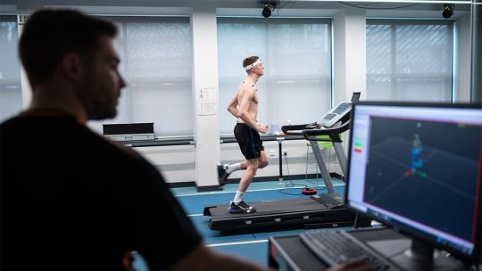 A Sports Therapy student on a treadmill as another student monitors performance on a computer.