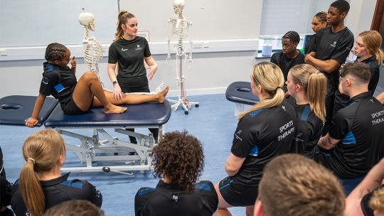 A group of Sports Therapy students watching a demo being given by a fellow student.