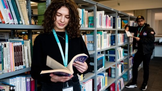female student in library looking at books