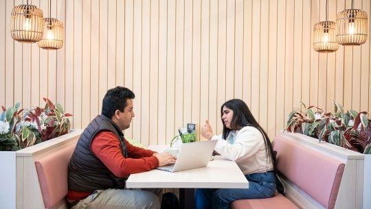 Two students in a booth at the Garden Cafe