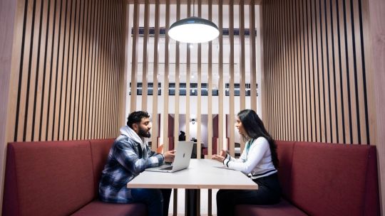 Students studying in a booth in the Atrium