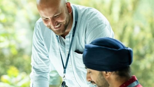 Two men talking together in the library