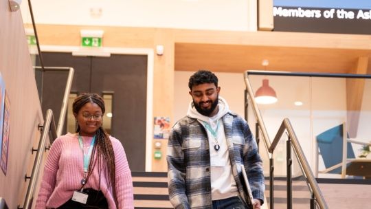 Students walking around campus in the atrium