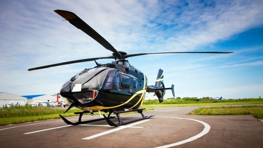 A black helicopter on a landing pad
