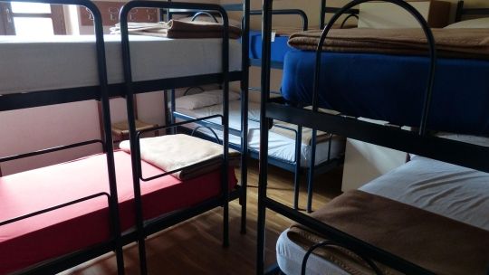 A small room in a hostel filled with bunk beds