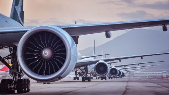 wing of 7 airplanes lined up on a runway behind each other