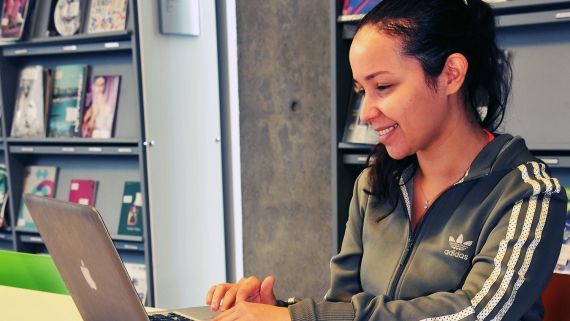 Woman sat at a laptop smiling