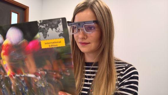 A woman reading whilst wearing eye tracking glasses 