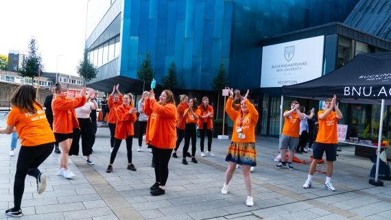 group of freshers helpers dancing outside the gateway building