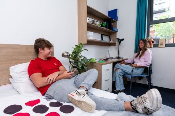 Male and female students talking in a bedroom at Hughenden accommodation