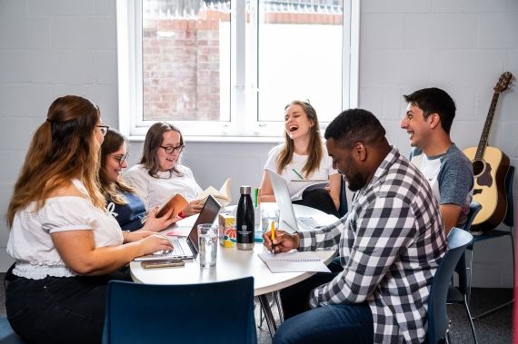 Group of students sitting at the table at Brook Street accommodation in High Wycombe campus