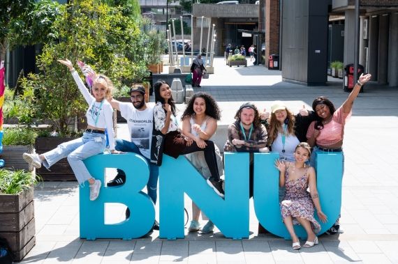 BNU students outside Gateway on sign